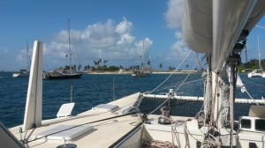 At anchor at Porvenir.  Included in photo is customs/immigration office, airport, and hotel.  Also our new BPO friends Maggie (just in front of our daggerboard) and Coconut Woman (in front of Maggie).