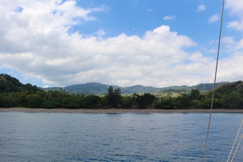 Tisvel Village, in the shadows. On the beach there is cacao and bamboo slats drying.