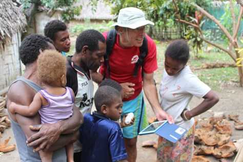 Photos on Bob's iPad are a hit. The white thing in the boy's hand is a cacao pod.