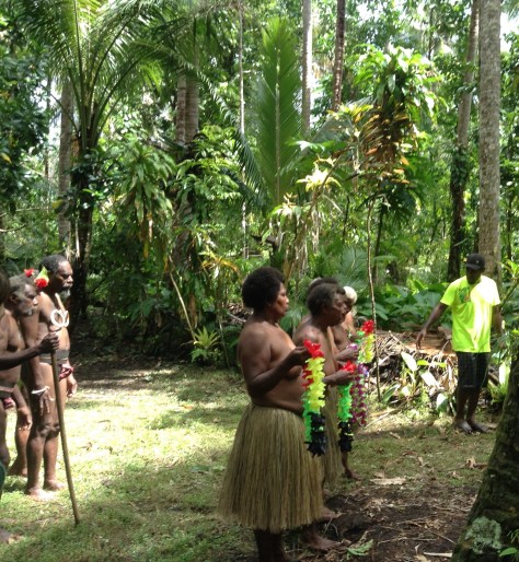 We're told to wait in the bush; then here comes the traditional welcome.