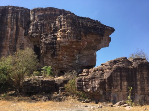 There is a vertical crack in the rocks, under the highest overhang to the right. Young men throw spears at it. Yes, from the level where the photo is taken! If they get their spear lodged into the crack, they become a spear-throwing superstar.