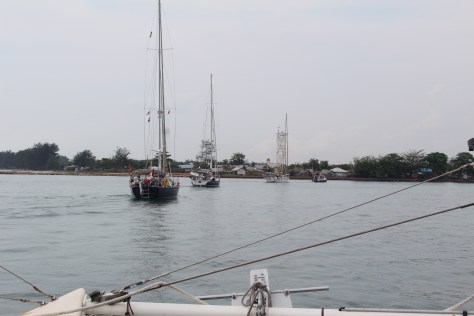 A pilot boat leads our little fleet over the bar and into the river, where we anchor off of the town of Manggar.